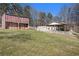 View of the large barn, garage and white fencing creating a perfect rural or equestrian property at 346 Mays Rd, Stockbridge, GA 30281