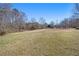 View of the expansive backyard, with an outbuilding and large lawn with mature trees at 346 Mays Rd, Stockbridge, GA 30281