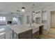 Open kitchen layout with a large central island, stainless steel faucet, custom cabinets, and a view into the living area at 4348 Hamilton Mill Rd, Buford, GA 30518