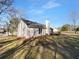 Backyard view displaying lush lawn, mature trees, home exterior with chimney, and a patio deck at 1720 Winners Cir, Lawrenceville, GA 30043