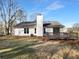 Backyard view featuring a wood deck, lush lawn, and a well-maintained home with a fenced area and landscaping at 1720 Winners Cir, Lawrenceville, GA 30043
