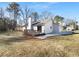 Backyard view featuring a deck, lush lawn, and mature trees with a home exterior in good condition at 1720 Winners Cir, Lawrenceville, GA 30043