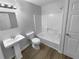 Bathroom featuring new flooring, white vanity, and a tub and shower combination at 1720 Winners Cir, Lawrenceville, GA 30043