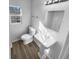 Bright bathroom features a pedestal sink, updated fixtures and a window for natural light at 1720 Winners Cir, Lawrenceville, GA 30043