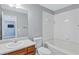 Clean bathroom featuring tile tub surround, a cherry wood vanity, and sleek fixtures, creating a calming space at 2565 Rocky Ct, South Fulton, GA 30349