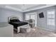 Spacious bedroom with elegant tray ceilings, a modern chandelier, and ample natural light from large windows at 2565 Rocky Ct, South Fulton, GA 30349
