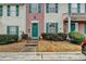 Close-up of a townhouse entrance featuring a green door, brick accents, and well-maintained landscaping at 3154 Panthers Trce, Decatur, GA 30034