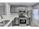 This kitchen features stainless steel appliances, gray cabinets, and quartz countertops at 3154 Panthers Trce, Decatur, GA 30034
