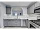Tastefully designed kitchen showcases gray cabinets, stainless steel appliances, and an open view to the living room at 3154 Panthers Trce, Decatur, GA 30034