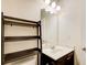 Modern bathroom with vanity, framed mirror and dark wood storage shelves at 563 Carleton Pl, Locust Grove, GA 30248