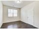 A cozy bedroom featuring dark hardwood floors, a window, and white trim at 563 Carleton Pl, Locust Grove, GA 30248