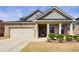 Charming brick home featuring a two-car garage, covered front porch, and manicured landscaping at 563 Carleton Pl, Locust Grove, GA 30248