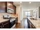 Stylish kitchen featuring granite countertops, modern appliances, and dark wood cabinetry at 563 Carleton Pl, Locust Grove, GA 30248