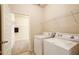 Convenient laundry room featuring modern washer and dryer with wire shelving at 563 Carleton Pl, Locust Grove, GA 30248