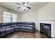 Bright living room with a fireplace, hardwood floors, and a modern ceiling fan at 563 Carleton Pl, Locust Grove, GA 30248