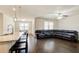 Open-concept living space with a large sectional couch, wood floors, and bright windows at 563 Carleton Pl, Locust Grove, GA 30248