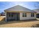 Home exterior featuring an enclosed porch, neutral siding, and well-maintained landscaping at 563 Carleton Pl, Locust Grove, GA 30248
