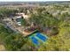 Aerial view of community tennis courts, pool and clubhouse surrounded by green trees at 313 Revolution Dr, Peachtree City, GA 30269