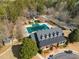 Aerial view of neighborhood clubhouse with pool, playground, tennis courts and mature trees at 313 Revolution Dr, Peachtree City, GA 30269