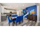 Bright dining area featuring gray walls, wood floors, and blue accent chairs near an open kitchen at 313 Revolution Dr, Peachtree City, GA 30269