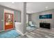 Cozy living room with gray walls, wood floors, a turquoise accent chair, and a vibrant orange front door at 313 Revolution Dr, Peachtree City, GA 30269