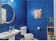 Contemporary powder room with a vessel sink, modern fixtures, and blue accent wall with eye-catching art at 313 Revolution Dr, Peachtree City, GA 30269