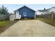 Backyard view showcasing a blue home with an ample concrete parking area at 318 Kelly Se St, Atlanta, GA 30312