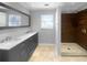 Bathroom featuring double sink vanity with marble countertop and walk-in shower with tile surround at 318 Kelly Se St, Atlanta, GA 30312