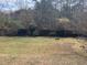 Expansive backyard with lush greenery, a wooden fence, mature trees, and a bench at 355 Tait Rd, Stockbridge, GA 30281