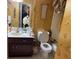 Bathroom with a toilet, sink, and a decorative hanging sign and patterned wall at 355 Tait Rd, Stockbridge, GA 30281