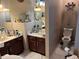 Well-lit bathroom featuring double sinks, brown cabinetry, toilet, and decorative accents at 355 Tait Rd, Stockbridge, GA 30281