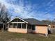 Exterior view of a peach-colored home with a screened-in porch and manicured lawn at 355 Tait Rd, Stockbridge, GA 30281