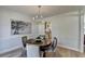 Dining room features a decorative chandelier, wainscoting, neutral paint and wood floors at 3736 Rainbow Cir, Snellville, GA 30039