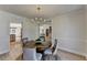 Dining room features a decorative chandelier, wainscoting, neutral paint and wood floors at 3736 Rainbow Cir, Snellville, GA 30039