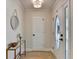 Inviting foyer featuring tile flooring, a decorative console table, and a view of the glass-paneled front door at 3736 Rainbow Cir, Snellville, GA 30039