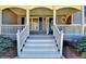 Inviting front porch with white railings and steps leading to the front door with a charming round window at 3736 Rainbow Cir, Snellville, GA 30039