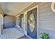 Covered front porch featuring a stylish front door with an oval glass insert and decorative floral arrangement at 3736 Rainbow Cir, Snellville, GA 30039