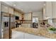 Well-lit kitchen features stainless steel refrigerator, granite countertops, and a mosaic tile backsplash at 3736 Rainbow Cir, Snellville, GA 30039