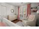 Bright Bedroom with shuttered windows includes a glider, changing table, and white-painted crib at 108 Great Oaks Lane, Roswell, GA 30075