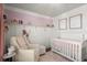 Charming Bedroom with pink accents features a cozy armchair and a comfortable white crib at 108 Great Oaks Lane, Roswell, GA 30075