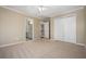 A bright bedroom features neutral carpet, a ceiling fan, and view to the stairwell and bathroom at 1678 Valor Ridge Nw Dr, Kennesaw, GA 30152