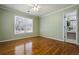 A bright bedroom features hardwood floors, a ceiling fan, and a window for natural light at 1678 Valor Ridge Nw Dr, Kennesaw, GA 30152