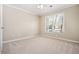 A bright bedroom features neutral carpet, a ceiling fan, and a window for natural light at 1678 Valor Ridge Nw Dr, Kennesaw, GA 30152