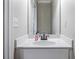 A well-lit powder room featuring a modern sink, a mirror, and white walls at 1678 Valor Ridge Nw Dr, Kennesaw, GA 30152