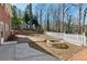 Spacious backyard with a fire pit, brick patio, white picket fence, and natural landscape at 3250 N Embry Cir, Atlanta, GA 30341