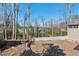 Landscaped backyard, featuring a brick patio, a white picket fence, and a wooded view at 3250 N Embry Cir, Atlanta, GA 30341