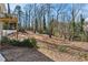 Large backyard with trees, sloped terrain, deck, and a fence at 3250 N Embry Cir, Atlanta, GA 30341