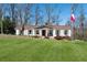 Charming ranch-style home with lush green lawn and manicured landscaping featuring an flagpole in the front yard at 3250 N Embry Cir, Atlanta, GA 30341