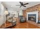 Open-concept living room featuring a brick fireplace, hardwood floors, and two reclining chairs at 3250 N Embry Cir, Atlanta, GA 30341