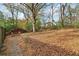 Expansive backyard with natural landscaping, mature trees and a stone pathway leading to a seating area at 761 Bellemeade Nw Ave, Atlanta, GA 30318